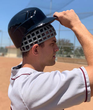 Baseball player wearing Head Net protective headgear under baseball helmet